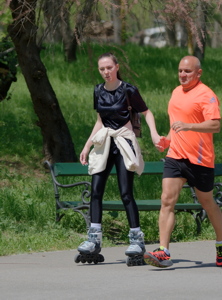 Woman rollerblading with a man running